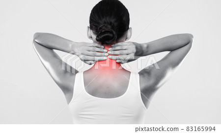 Back view of unrecognizable woman touching and massaging her neck 83165994