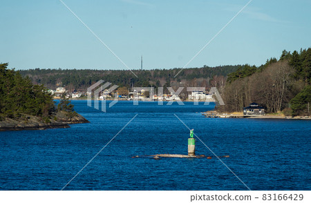 Picturesque summer houses painted in traditional falun red on dwellings island of the Stockholm archipelago in the Baltic Sea in the early morning. 83166429
