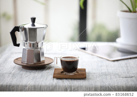 Moka pot and a glass cup of coffee  83168652