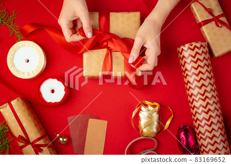 Hands of woman holding christmas gift box on a red background 83169652