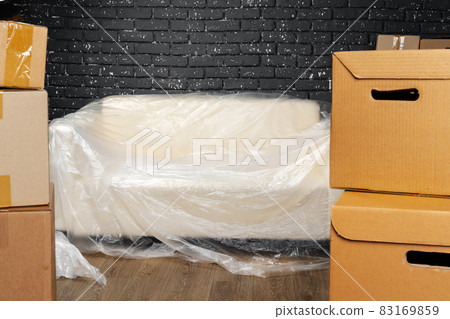 Moving in or moving out concept. Stack of boxes and packed furniture Moving in or moving out concept. Stack of boxes and packed furniture 83169859