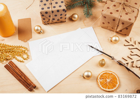 Greeting letter, envelope and feather surrounded by Christmas decorations 83169872