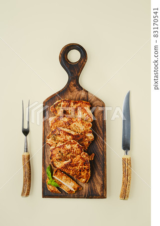 Top view of fried chopped pork tenderloin on wooden cutting board 83170541