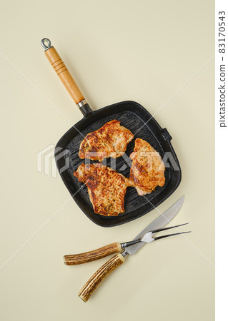 Top view of fried chopped pork tenderloin on frying pan 83170543