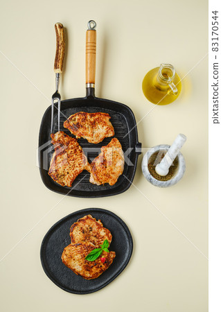 Top view of fried chopped pork tenderloin on plate and pan Top view of fried chopped pork tenderloin on plate and pan 83170544