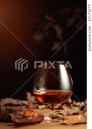 Snifter of brandy and dried-up oak leaves. 83173077