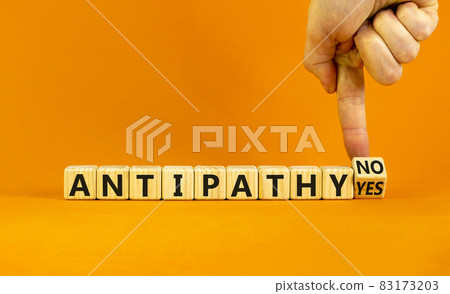 Antipathy yes or no symbol. Psychologist turns a wooden cube and change words 'antipathy no' to 'antipathy yes'. Beautiful orange background. Business and antipathy yes or no concept, copy space. 83173203