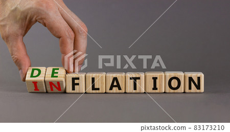 Inflation or deflation symbol. Businessman turns cubes and changes the word inflation to deflation. Beautiful grey background, copy space. Business, inflation or deflation concept. 83173210