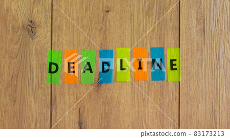 Deadline symbol. Concept word 'deadline' on colored papers on a beautiful wooden background, copy space. Business and deadline concept. 83173213