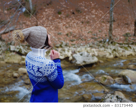 Beautiful woman standing among trees in winter forest 83173440