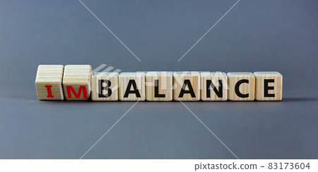 Balance or imbalance symbol. Turned cubes and changed the word imbalance to balance. Beautiful grey background, copy space. Business, balance or imbalance concept. Balance or imbalance symbol. Turned cubes and changed the word imbalance to balance. Beautiful grey background, copy space. Business, balance or imbalance concept. 83173604