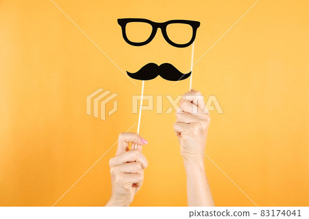 Paper party attributes in form of mustache on wooden stick. Carnival accessory concept. Paper party attributes in form of mustache on wooden stick. Carnival accessory concept. 83174041