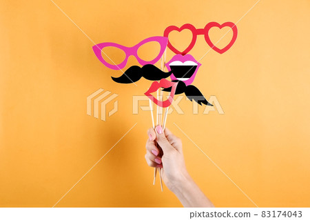 Paper party attributes in form of mustache on wooden stick. Carnival accessory concept. Paper party attributes in form of mustache on wooden stick. Carnival accessory concept. 83174043
