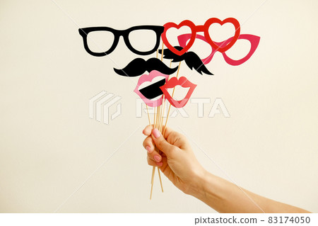 Paper party attributes in form of moustache on wooden stick. Carnival accessory concept. Paper party attributes in form of moustache on wooden stick. Carnival accessory concept. 83174050