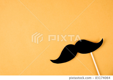 Paper party attributes in form of mustache on wooden stick. Carnival accessory concept. Paper party attributes in form of mustache on wooden stick. Carnival accessory concept. 83174064