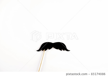 Paper party attributes in form of mustache on wooden stick. Carnival accessory concept. Paper party attributes in form of mustache on wooden stick. Carnival accessory concept. 83174086