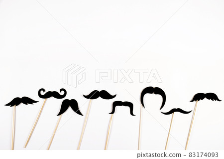 Paper party attributes in form of mustache on wooden stick. Carnival accessory concept. Paper party attributes in form of mustache on wooden stick. Carnival accessory concept. 83174093