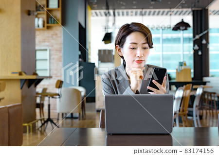 在一家咖啡館經營智能手機的女商人 83174156