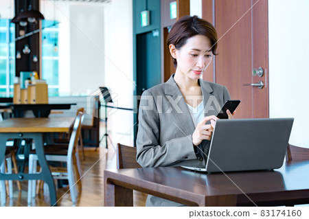 在一家咖啡館經營智能手機的女商人 83174160