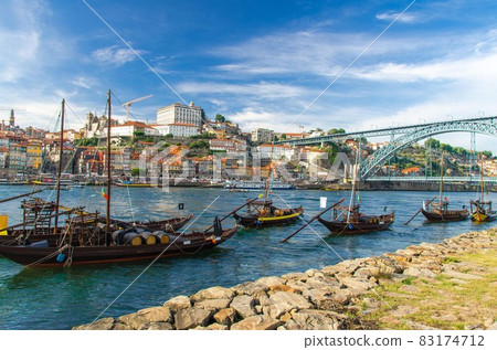 Portugal, city landscape Porto, wooden boats with wine port barrels close up on Douro river 83174712