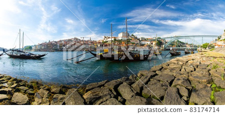 Portugal, city landscape Porto, wooden boats with wine port barrels close up on Douro river 83174714