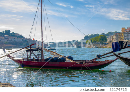 Portugal, city landscape Porto, wooden boats with wine port barrels close up on Douro river 83174715