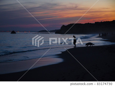 Portugal, Algarve, The best beaches of Portimao, Praia da Rocha, lilac golden sunset over the waves of The Atlantic Ocean 83174730