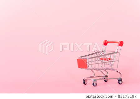 Shopping concept : Red shopping cart on pink background. online shopping consumers can shop from home and delivery service. with copy space Shopping concept : Red shopping cart on pink background. online shopping consumers can shop from home and delivery service. with copy space 83175197