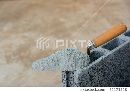Cement powder or mortar with trowel put on the Concrete brick for construction work.. Cement powder or mortar with trowel put on the Concrete brick for construction work.. 83175228