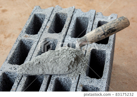 Cement powder or mortar with trowel put on the Concrete brick for construction work.. Cement powder or mortar with trowel put on the Concrete brick for construction work.. 83175232
