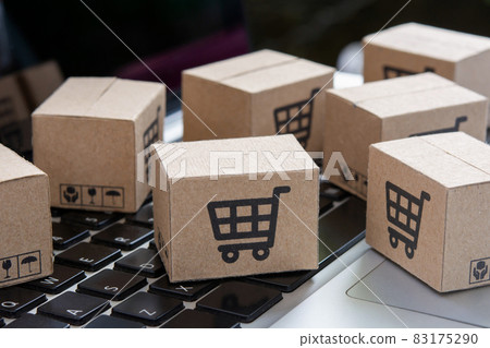 Online shopping - Paper cartons or parcel with a shopping cart logo on a laptop keyboard. Shopping service on The online web and offers home delivery.. Online shopping - Paper cartons or parcel with a shopping cart logo on a laptop keyboard. Shopping service on The online web and offers home delivery.. 83175290