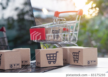 Shopping online - Parcel or Paper cartons with a shopping cart logo in a trolley on a laptop keyboard. Shopping service on The online web. offers home delivery. 83175293