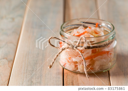 Homemade sauerkraut on a light wooden background. Glass jar with homemade fermented cabbage. Eco food, the trend of healthy eating. Place for your text. 83175861