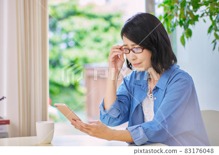 Middle-aged women with presbyopia who have difficulty seeing smartphones 83176048