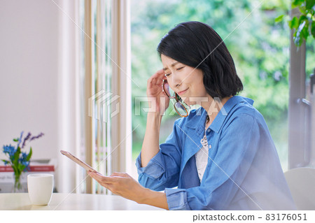 看智能手機有困難的老花眼中年女性 83176051