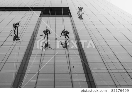 Men wash the windows of modern skyscraper. Men wash the windows of modern skyscraper. 83176499