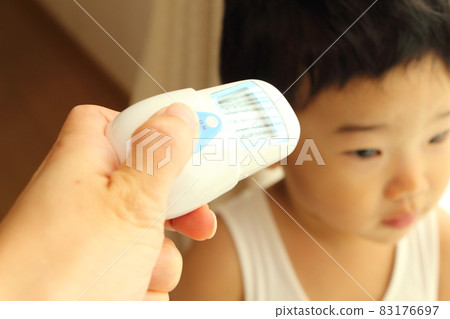 A boy taking a temperature measurement with a non-contact thermometer A boy taking a temperature measurement with a non-contact thermometer 83176697