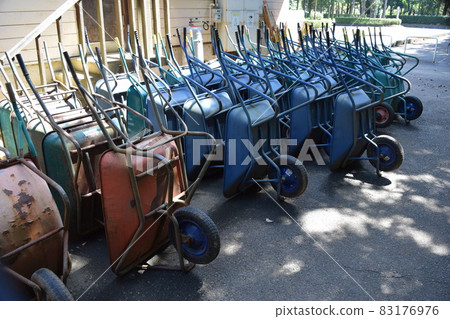 Multiple wheelbarrows leaning against 83176976