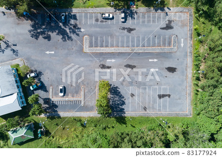 Aerial view top down of car parked at concrete car parking lot with white line of traffic sign on the street. Above view of car in a row at parking space Outside car parking area 83177924