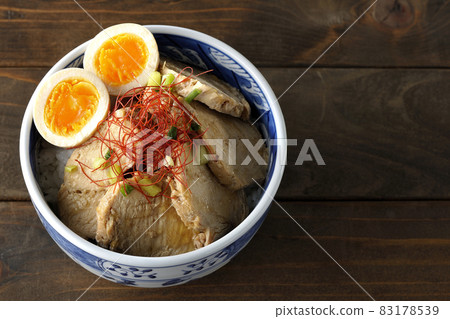A bird's-eye view of a chicken char siu bowl with boiled eggs, all-purpose green onions, and thread-cut chili peppers 83178539