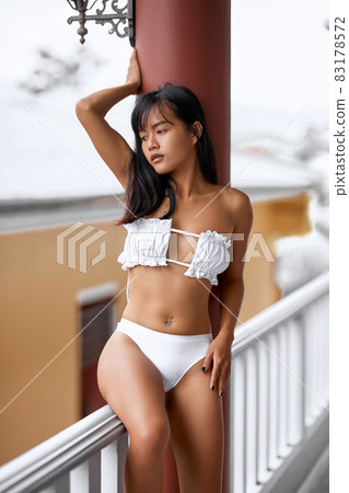 Asian young sexy girl in white lingerie sitting at the balcony Asian young sexy girl in white lingerie sitting at the balcony 83178572
