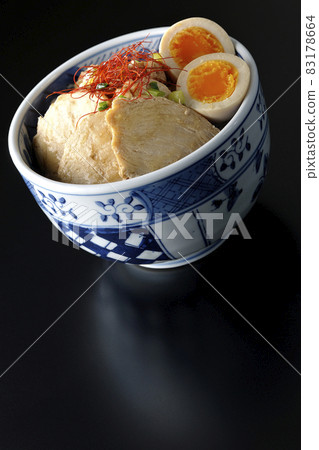 A chicken char siu bowl with boiled egg, all-purpose green onion and thread-cut chili pepper on a black background A chicken char siu bowl with boiled egg, all-purpose green onion and thread-cut chili pepper on a black background 83178664
