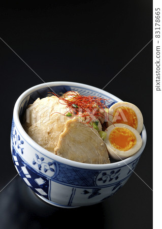 A chicken char siu bowl with boiled egg, all-purpose green onion and thread-cut chili pepper on a black background A chicken char siu bowl with boiled egg, all-purpose green onion and thread-cut chili pepper on a black background 83178665