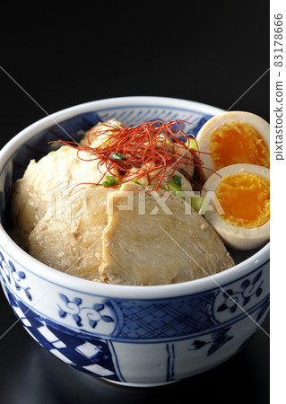 A chicken char siu bowl with boiled egg, all-purpose green onion and thread-cut chili pepper on a black background A chicken char siu bowl with boiled egg, all-purpose green onion and thread-cut chili pepper on a black background 83178666