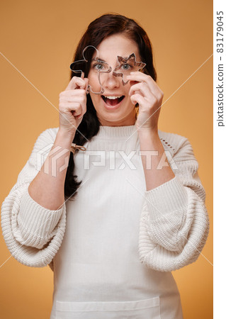 Woman pastry chef with metallic man shapes and stars for cookies. 83179045