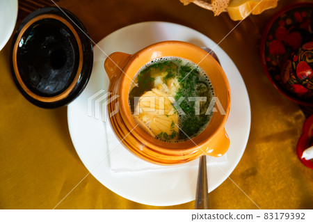 Fish soup with herbs in a pot. 83179392