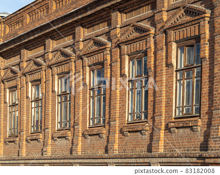 Brick wall of an old 19th century building with large windows. Wall of an old red brick building with six windows 83182008