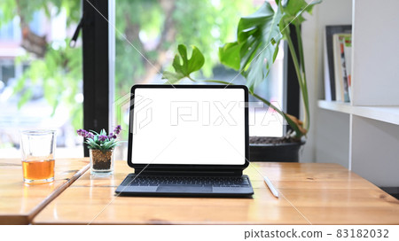 Mock up digital tablet with wireless keyboard on wooden table. 83182032