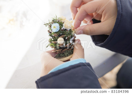 Elementary school students making a pine cone Christmas tree at the workshop Elementary school students making a pine cone Christmas tree at the workshop 83184396
