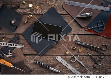 Leather craft or leather working. Leather working tools and cut out pieces of leather on work desk . Leather craft or leather working. Leather working tools and cut out pieces of leather on work desk . 83184788